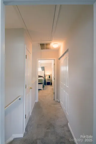 a view of a hallway with a livingroom and a bathroom