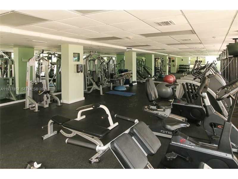 10185 Collins Avenue, Unit PH02 Bal Harbour, FL 33154 - Photo 24 of 37 a room with gym equipment and large mirror