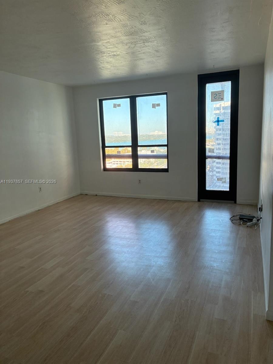 10185 Collins Avenue, Unit PH02 Bal Harbour, FL 33154 - Photo 29 of 37 an empty room with wooden floor and windows