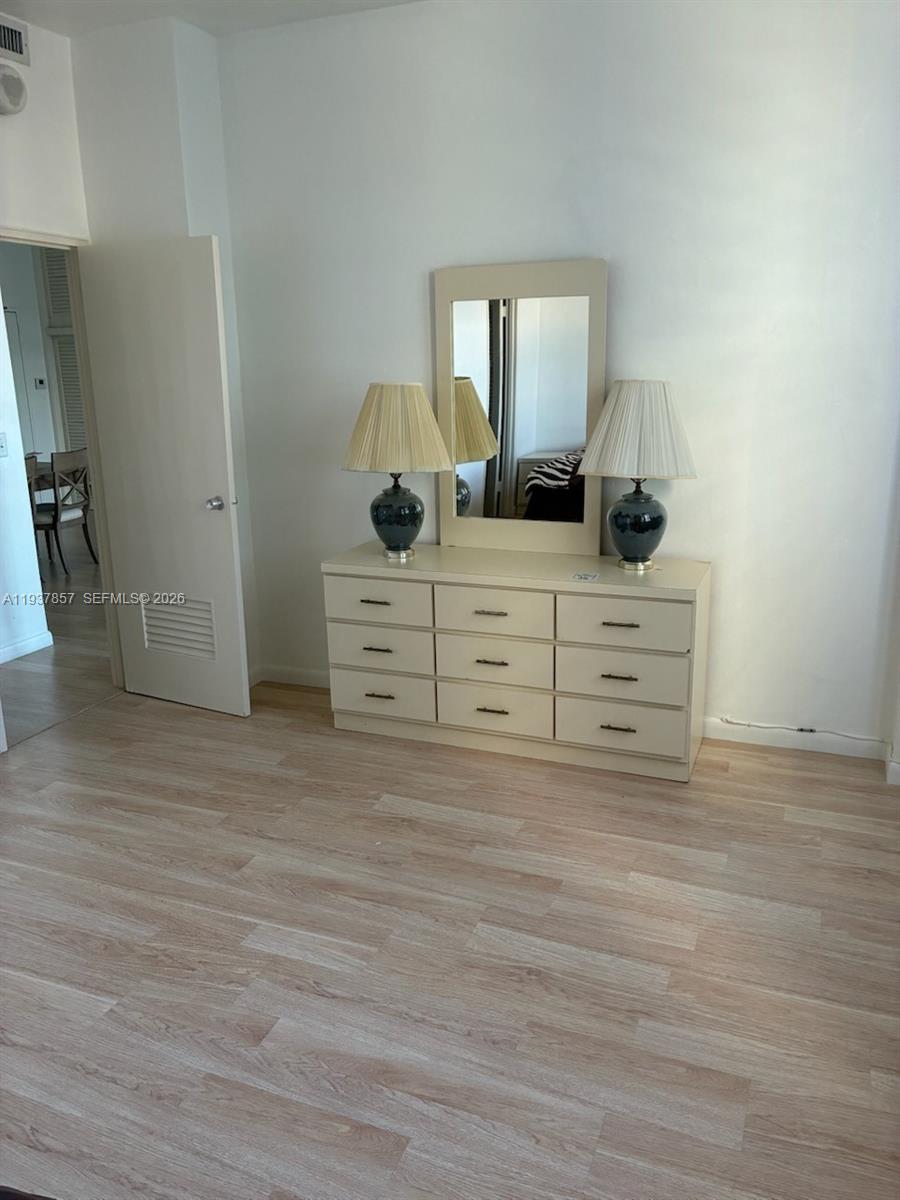 10185 Collins Avenue, Unit PH02 Bal Harbour, FL 33154 - Photo 35 of 37 a room with a bed and a potted plant on the dresser