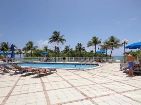 a view of a swimming pool with a patio and a yard
