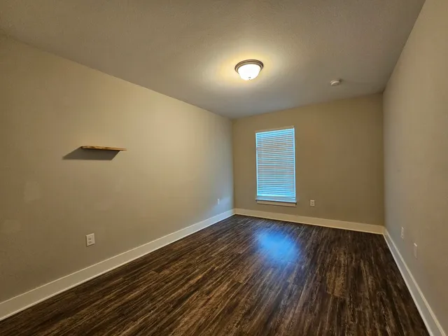 a view of room with window and wooden floor