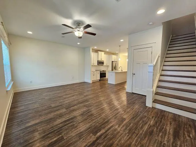 a view of a kitchen with wooden floor and a ceiling fan