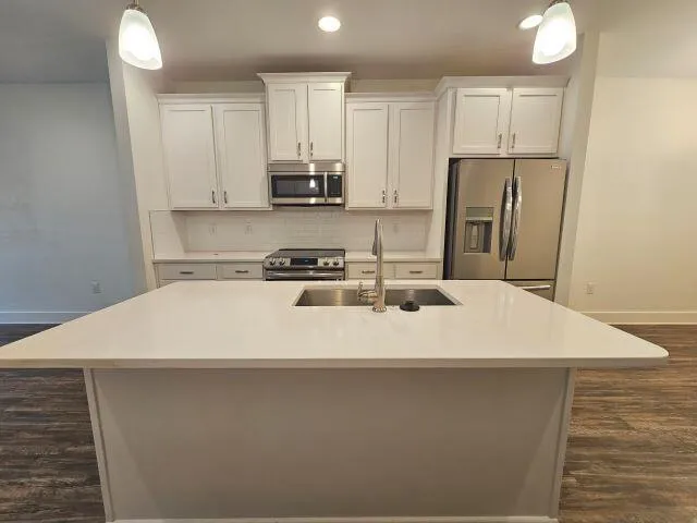 a large white kitchen with stainless steel appliances