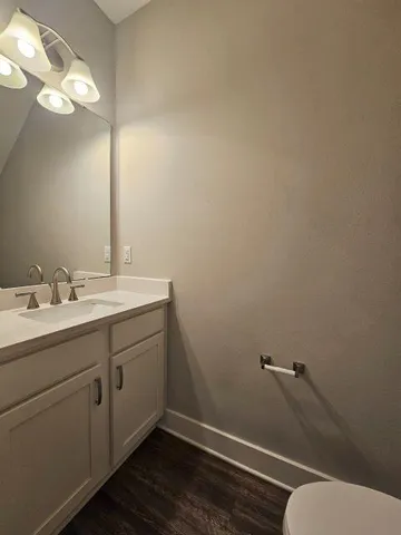 a bathroom with a toilet sink and mirror