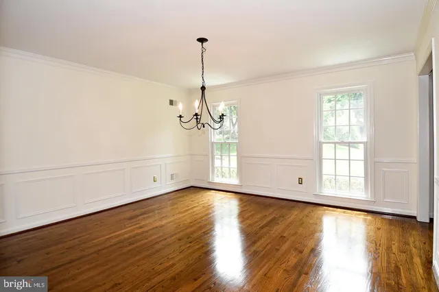 a view of empty room with wooden floor and window