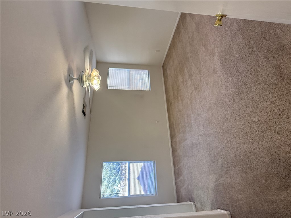 8108 Roundup Ridge Street Las Vegas, NV 89131 - Photo 18 of 21 A well-lit interior space with carpet flooring and sloped ceilings.