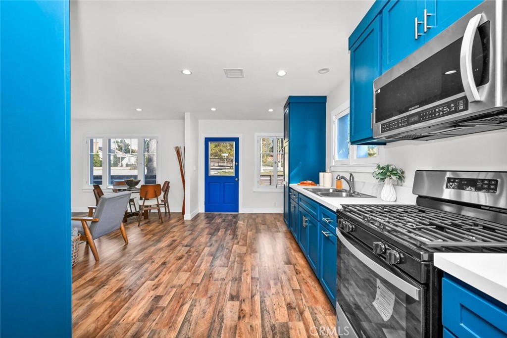 294 Bella Vista Avenue Pasadena, CA 91107 - Photo 18 of 37 a kitchen with stainless steel appliances granite countertop a stove top oven a sink dishwasher a dining table and chairs with wooden floor