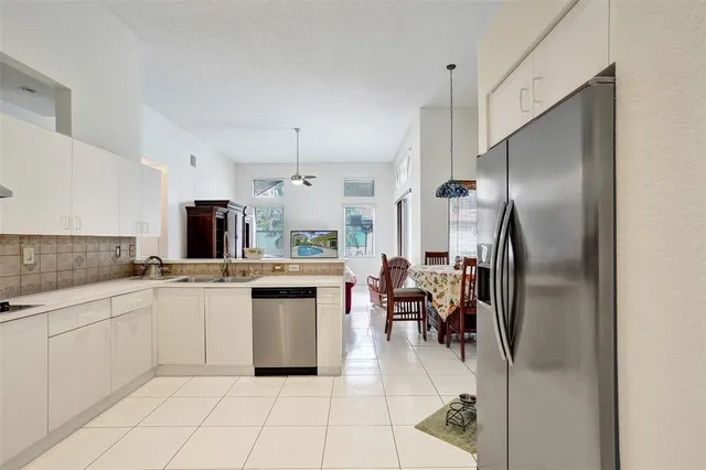 a kitchen with white cabinets and sink