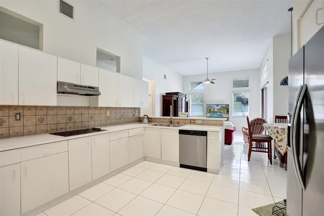 a kitchen with white cabinets sink and white appliances