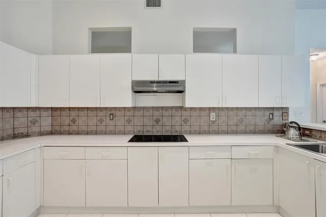 a kitchen with a sink and white cabinets