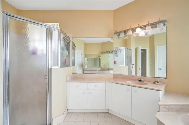 a bedroom with a bed a computer on desk and a dresser next to a window