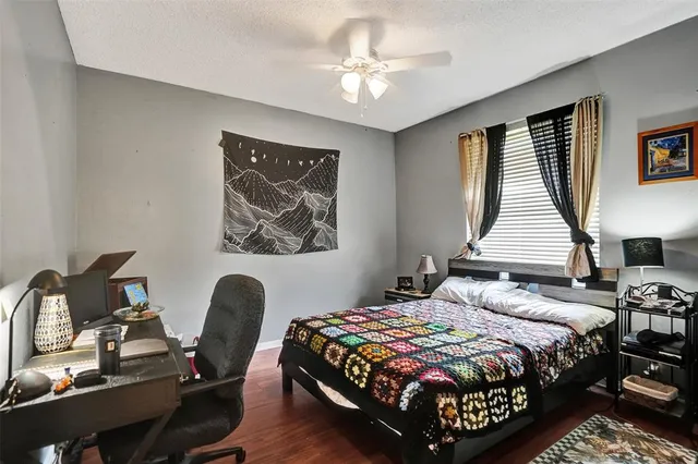 a bedroom with bed and a flat tv screen on dresser