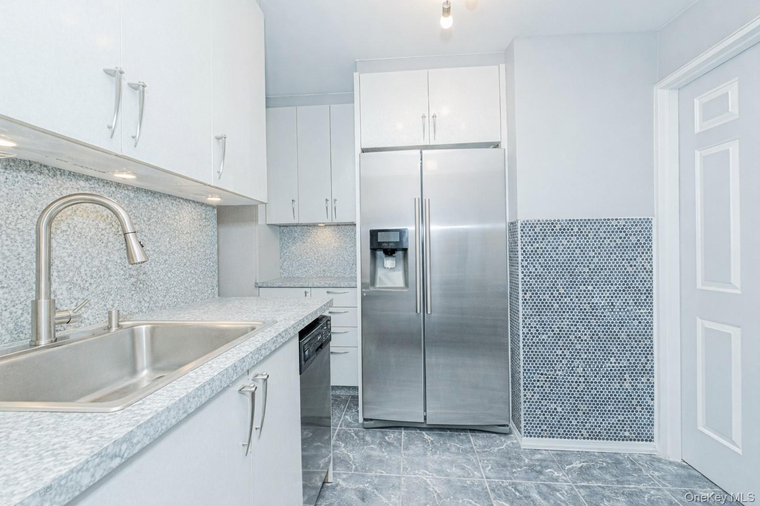 2400 East 3rd Street, Unit 607 Brooklyn, NY 11223 - Photo 11 of 21 a kitchen with stainless steel appliances granite countertop a refrigerator a sink and a stove