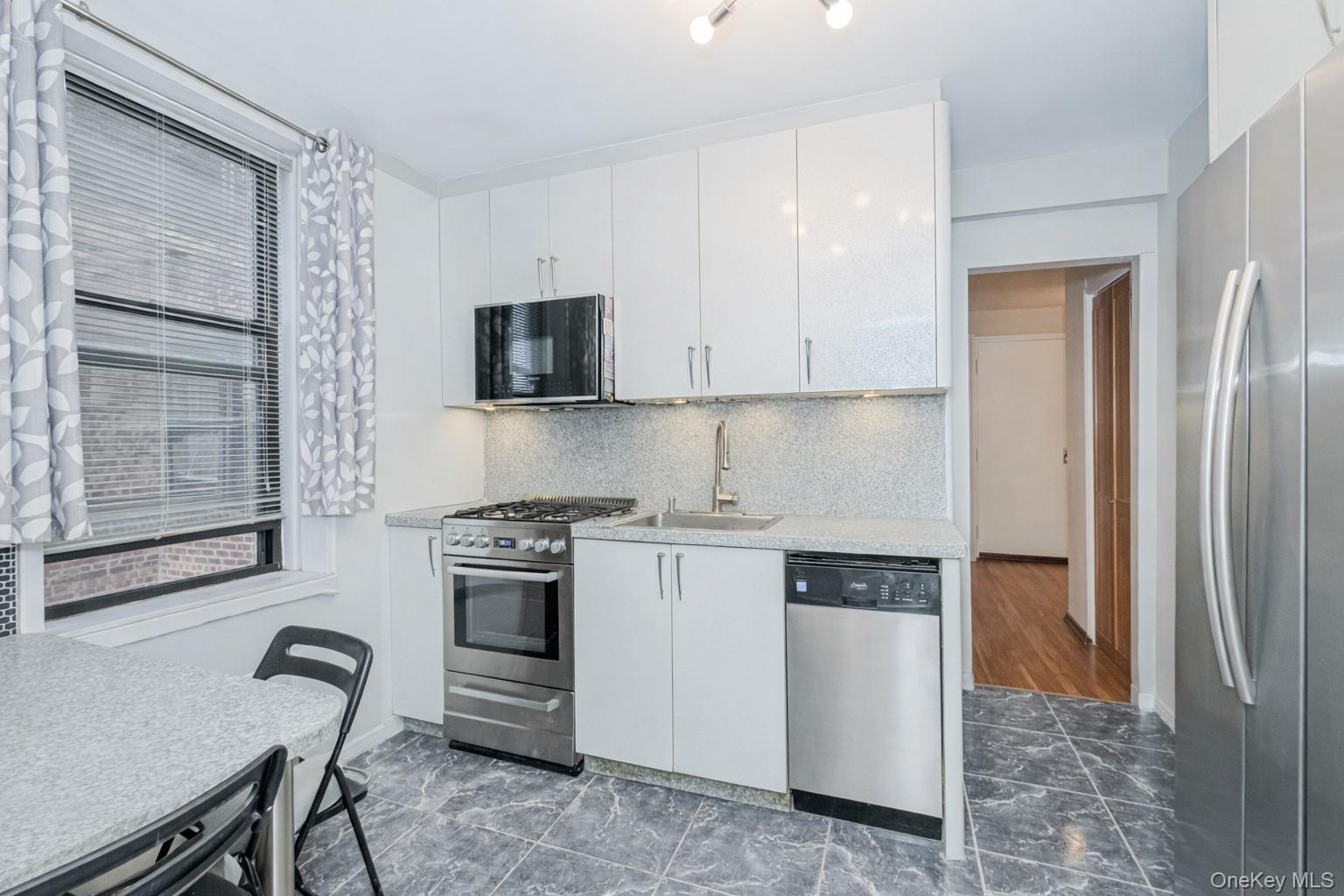 2400 East 3rd Street, Unit 607 Brooklyn, NY 11223 - Photo 13 of 21 a kitchen with stainless steel appliances granite countertop a stove and a refrigerator