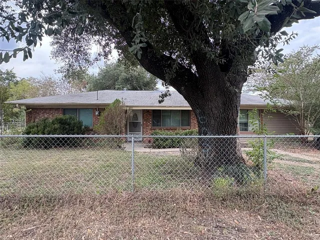 front view of a house with a tree in the yard