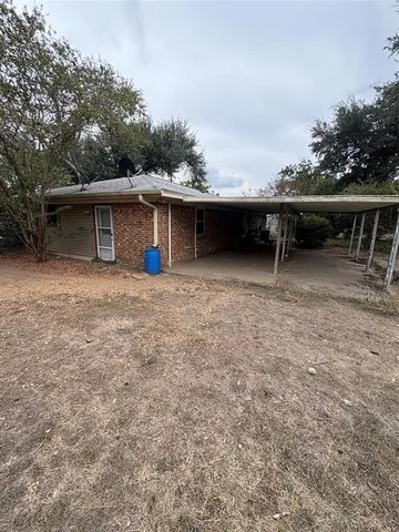 a backyard of a house with table and chairs
