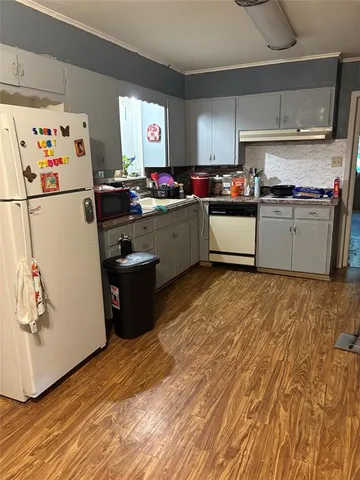 a kitchen with granite countertop a refrigerator and a sink