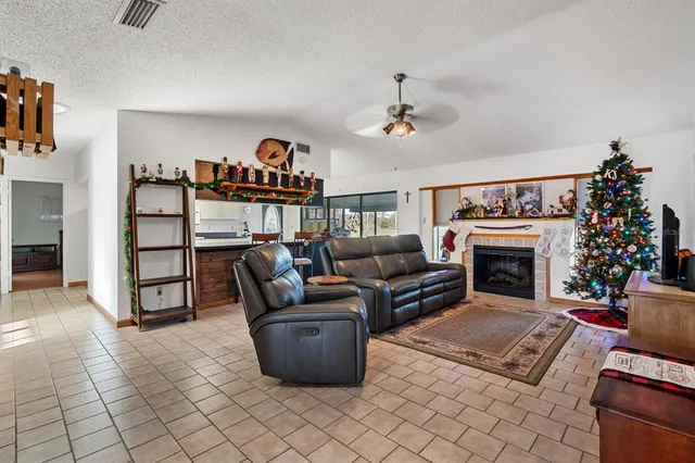 a kitchen with stainless steel appliances granite countertop a stove a refrigerator a microwave a dining table and chairs with wooden floor