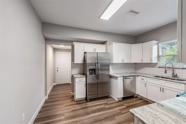 a kitchen with stainless steel appliances granite countertop a refrigerator and a sink