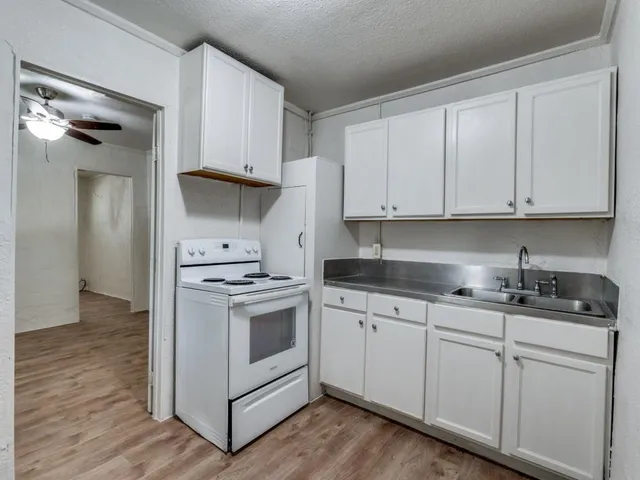 a kitchen with granite countertop white cabinets and white appliances