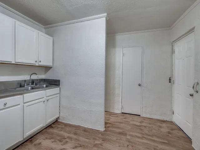 a kitchen with granite countertop white cabinets and sink