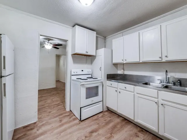 a kitchen with granite countertop a sink and a stove top oven
