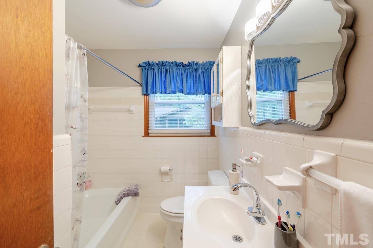 2804 Sparger Road Durham, NC 27705 - Photo 31 of 34 a bathroom with a sink a toilet and shower curtain