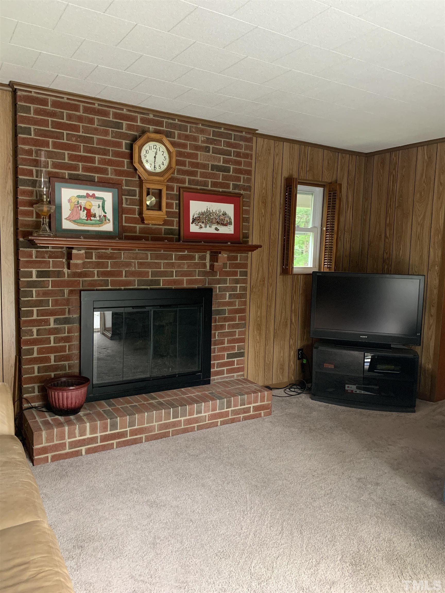 2804 Sparger Road Durham, NC 27705 - Photo 6 of 34 a living room with furniture a flat screen tv and a fireplace