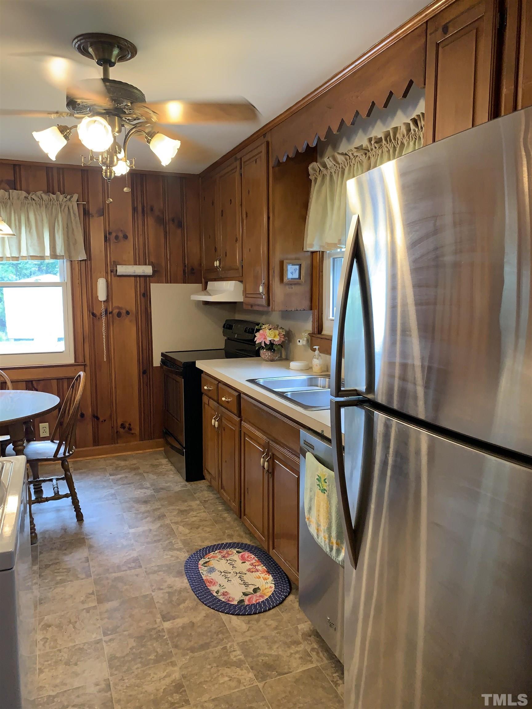 2804 Sparger Road Durham, NC 27705 - Photo 7 of 34 a kitchen with stainless steel appliances granite countertop a refrigerator a stove a sink and a dining table with white cabinets