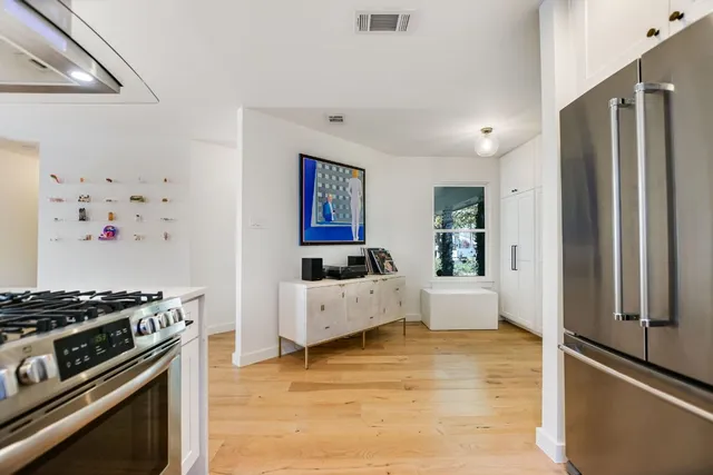 a kitchen with stainless steel appliances kitchen island a table and chairs in it