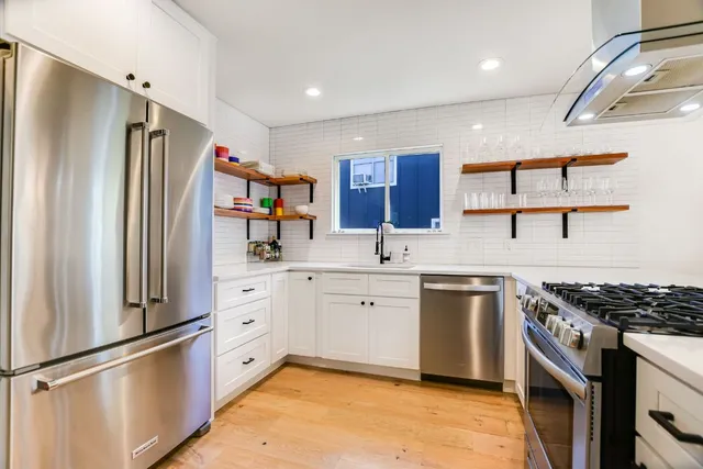 a kitchen with stainless steel appliances granite countertop a sink stove and refrigerator