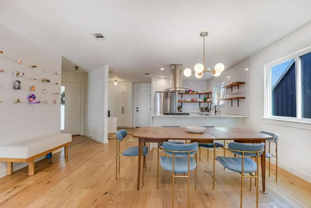 a kitchen with stainless steel appliances granite countertop a kitchen island a stove a table and chairs in it