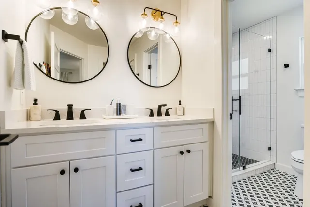 a bathroom with a double vanity sink mirror and bathtub