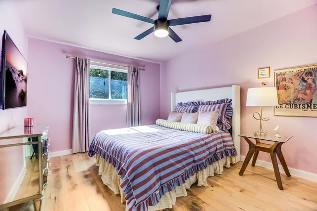 a bedroom with a bed table closet and a flat screen tv