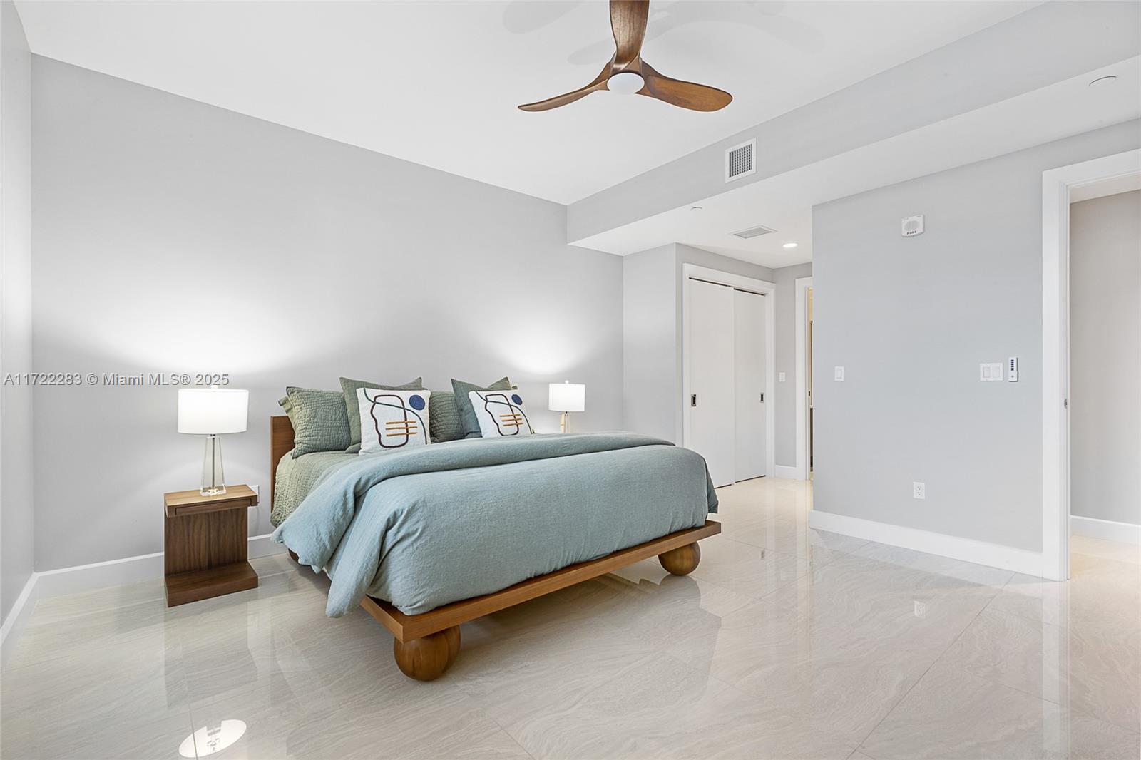 2720 Donald Ross Road, Unit 206 Palm Beach Gardens, FL 33410 - Photo 17 of 40 a spacious bedroom with a bed and a chandelier