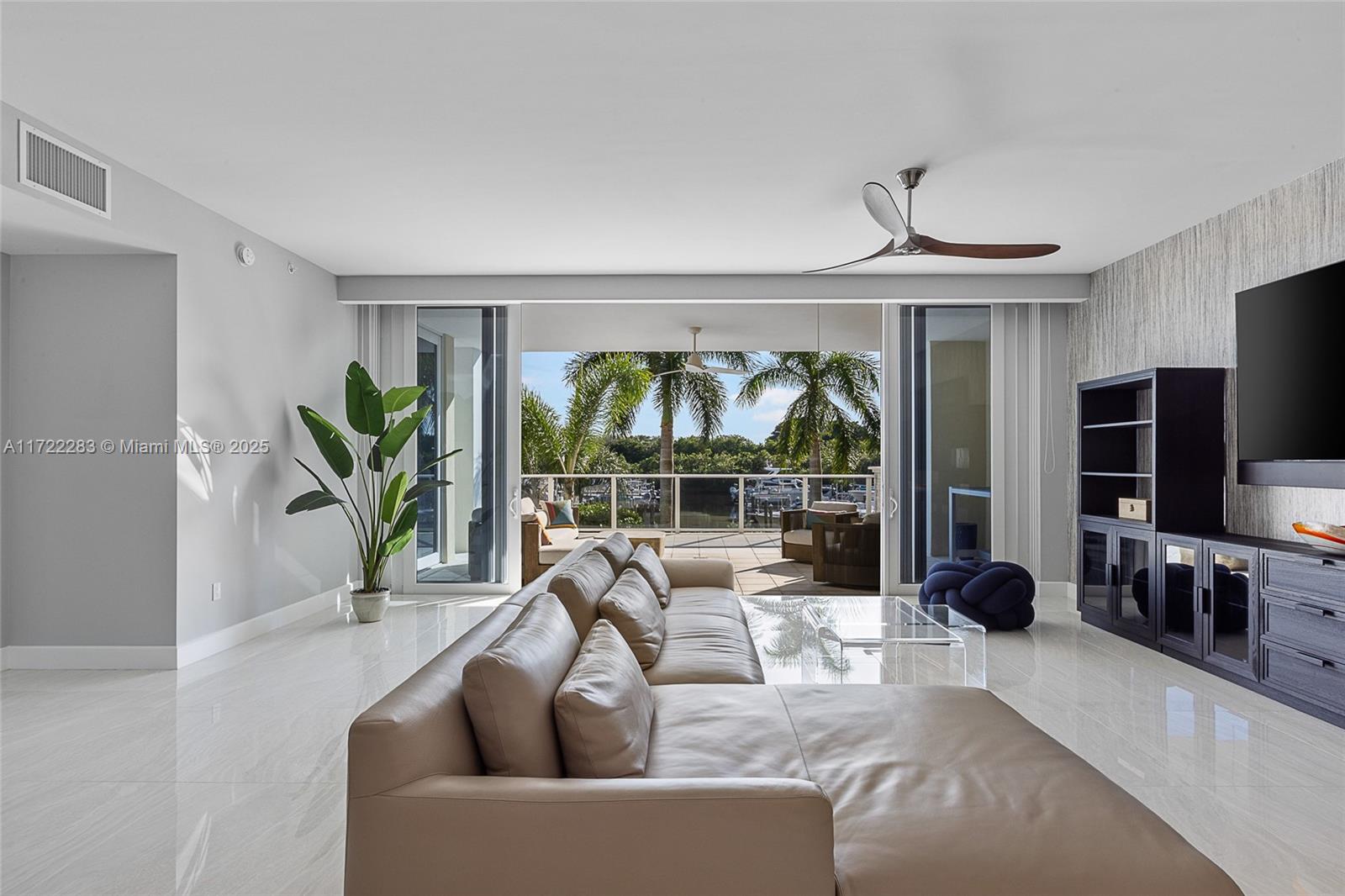 2720 Donald Ross Road, Unit 206 Palm Beach Gardens, FL 33410 - Photo 4 of 40 a living room with furniture a flat screen tv and a large window