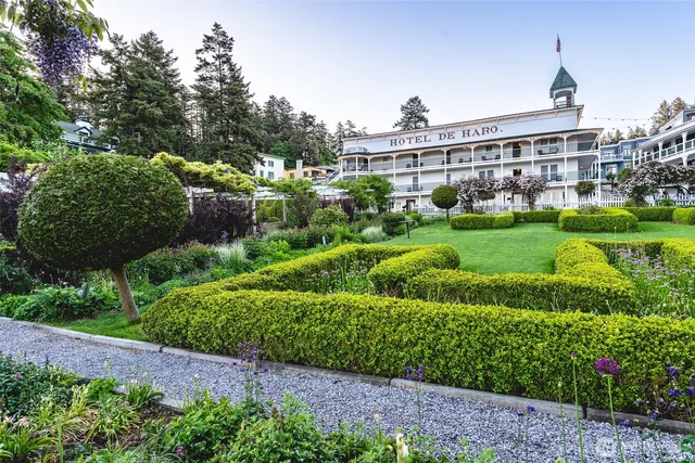 a view of a house with a yard and potted plants
