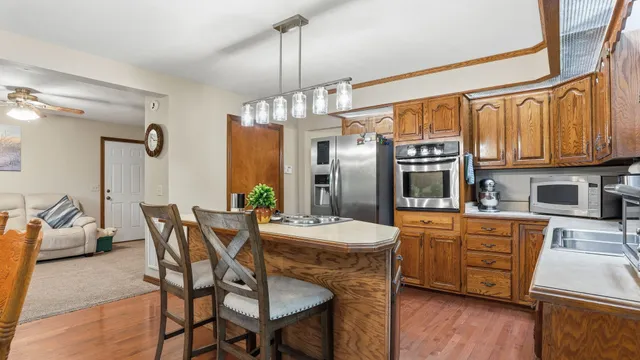 a dining room with furniture a chandelier and wooden floor