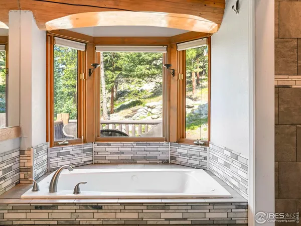 a bathroom with a bathtub and next to a window