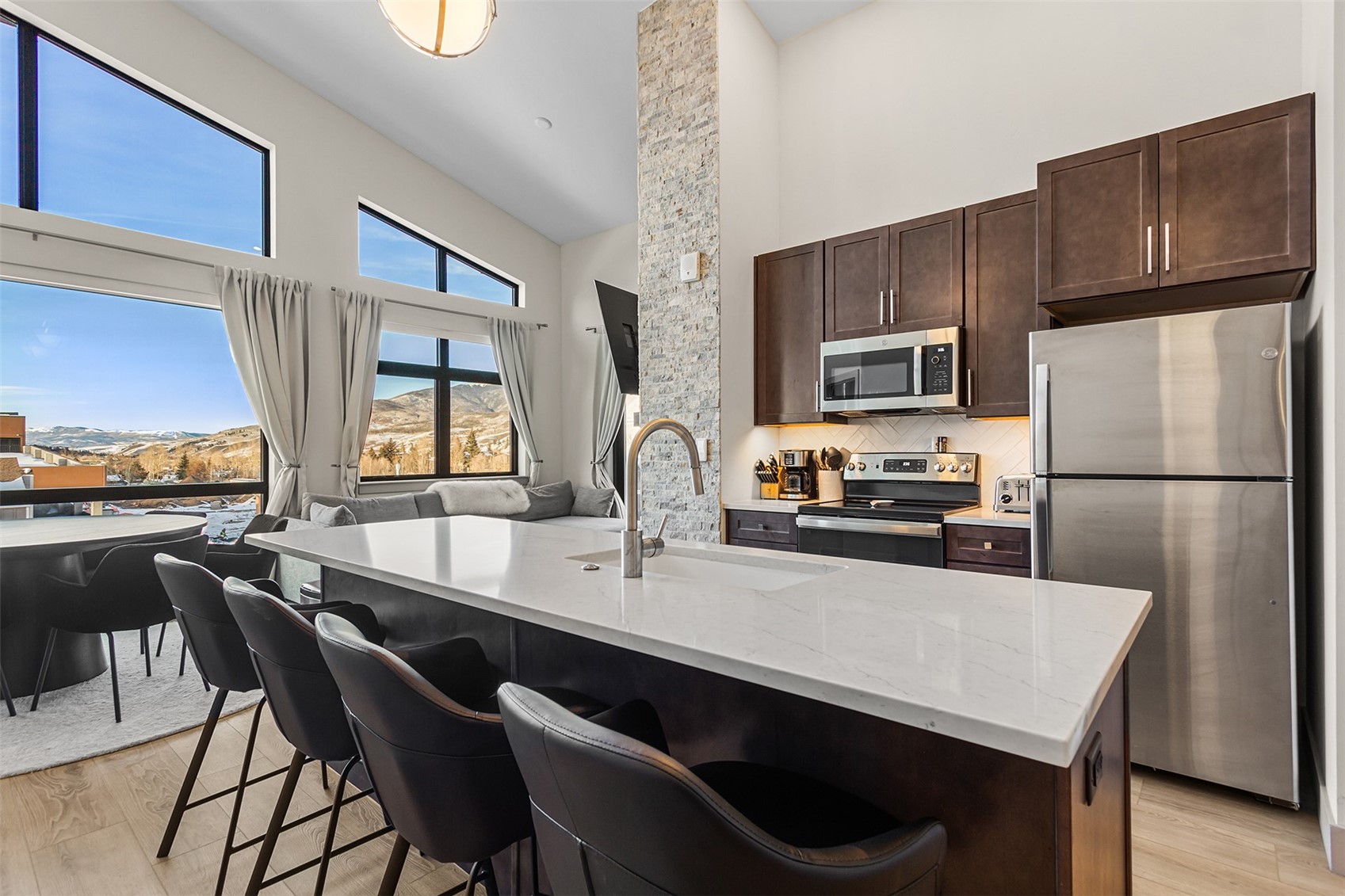 75 West 4th Street, Unit 305W Silverthorne, CO 80498 - Photo 2 of 30 a kitchen with a refrigerator a stove a sink dishwasher with a dining table and chairs