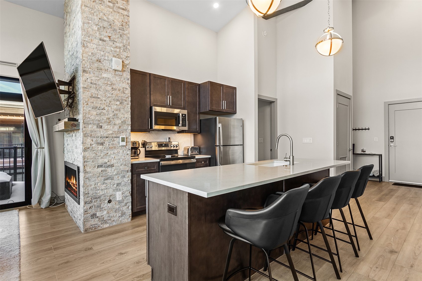 75 West 4th Street, Unit 305W Silverthorne, CO 80498 - Photo 3 of 30 a kitchen with stainless steel appliances a sink a stove a refrigerator cabinets and dining table