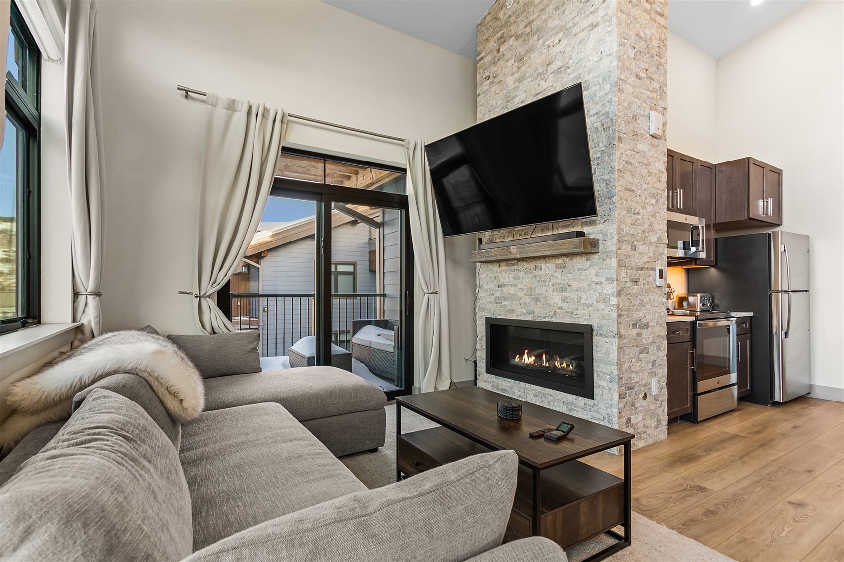 75 West 4th Street, Unit 305W Silverthorne, CO 80498 - Photo 7 of 30 a living room with couches a fireplace and a flat screen tv