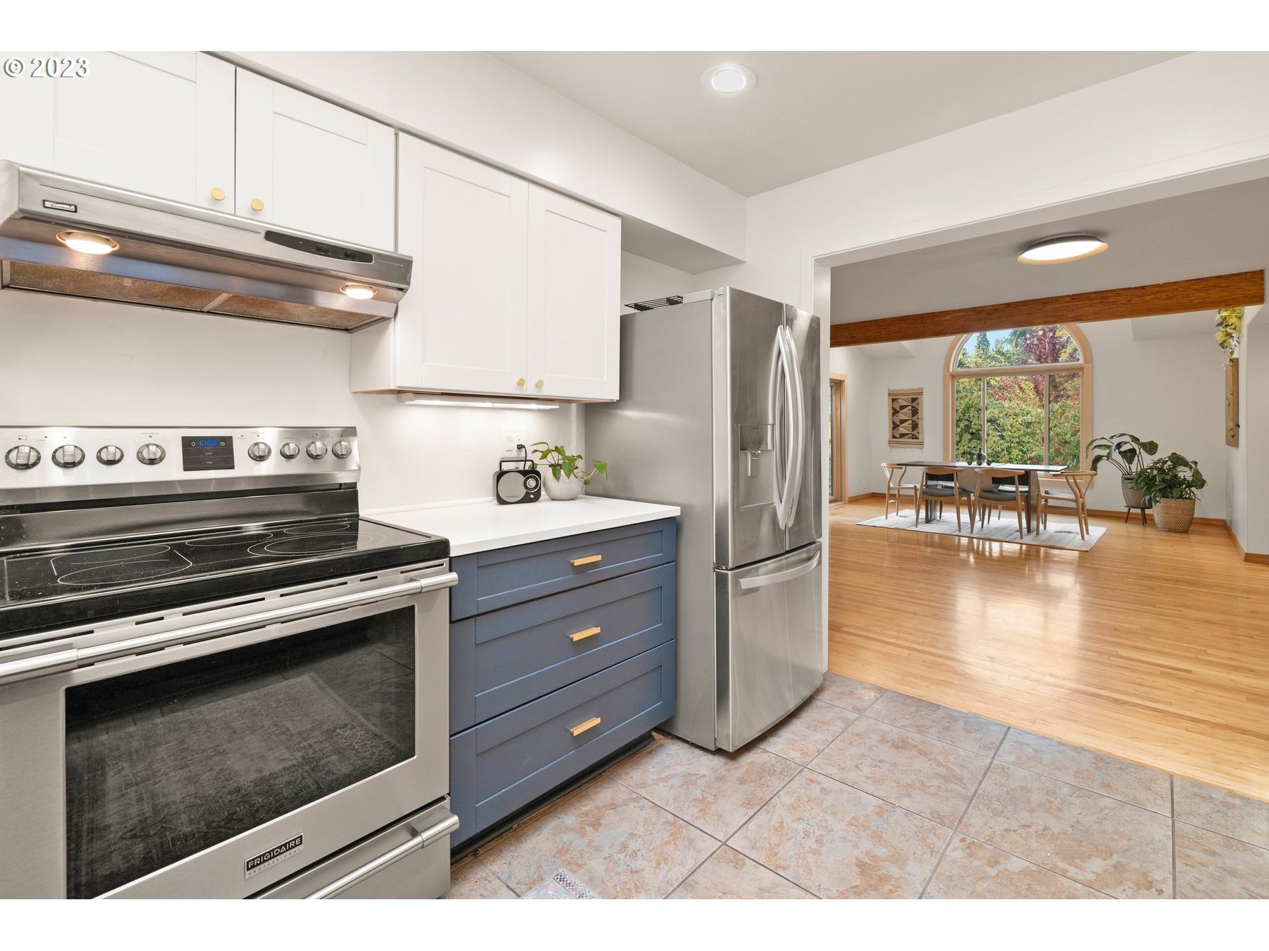 8425 Southwest Ridgeway Drive Portland, OR 97225 - Photo 9 of 41 a kitchen with stainless steel appliances kitchen island granite countertop a stove a refrigerator and a view of living room
