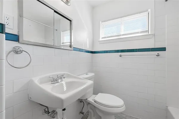 a bathroom with a sink a toilet and a mirror