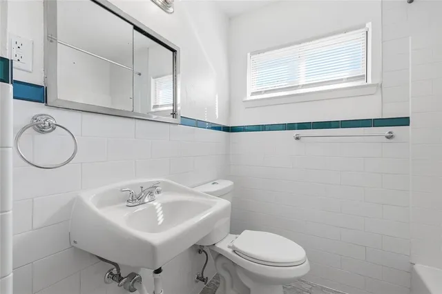 a bathroom with a sink a toilet and a mirror