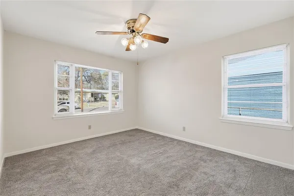 an empty room with a window and a fan