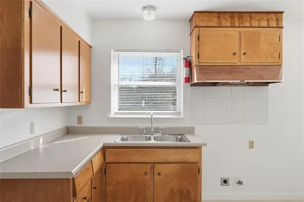 a kitchen with granite countertop white cabinets and window