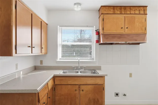 a kitchen with granite countertop white cabinets and window