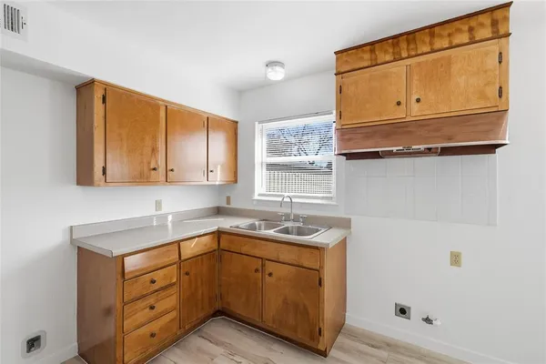 a kitchen with stainless steel appliances granite countertop a sink and dishwasher with wooden cabinets